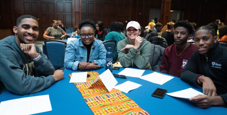 Students sitting around a table at Kwanzaa celebration